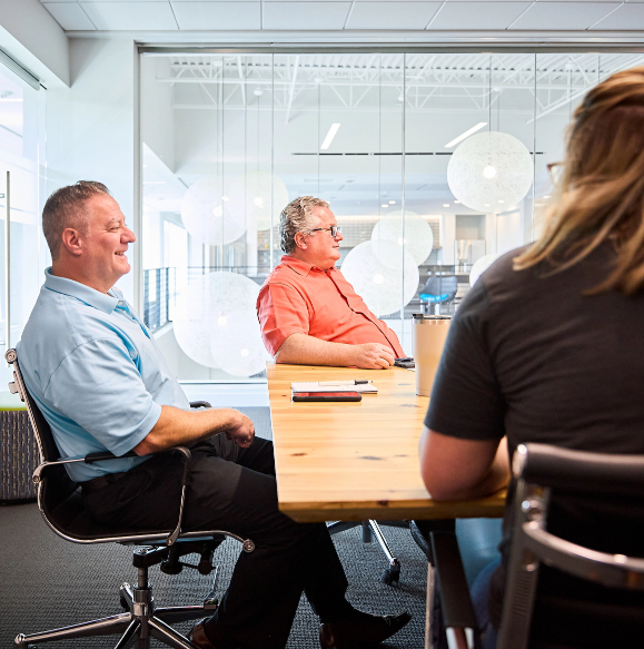 Workers compensation insurance become an agent Three BerkleyNet employees attentively participating in a meeting, in a collaborative environment at BerkleyNet workers compensation insurance.