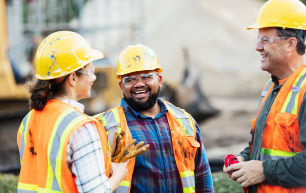 Construction workers Three smiling construction workers on a job site, representing the types of injured workers supported by BerkleyNet and focused on the risks of worker misclassification in insurance.