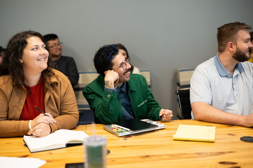 Three BerkleyNet employees sitting at a desk in the BerkleyNet, workers compensation insurance, office. 