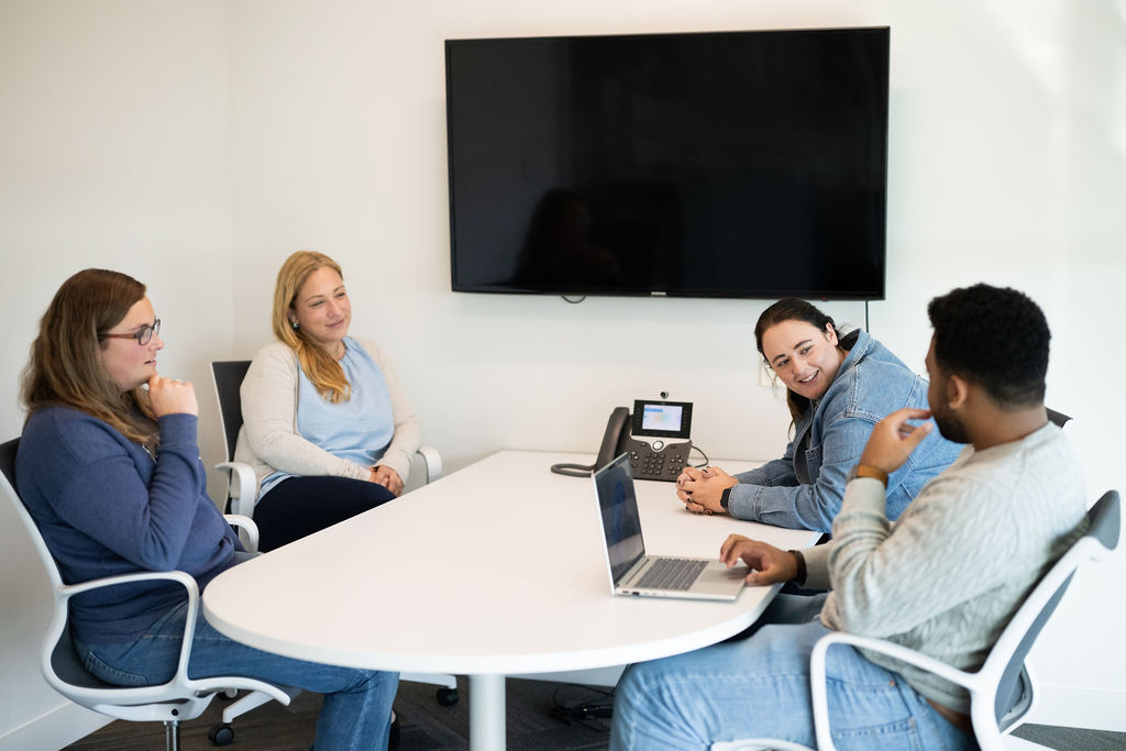 Premium Audit Process Four BerkleyNet employees attentively participating in a meeting for BerkleyNet, workers compensation insurance.